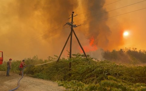 Personas riegan agua en un incendio el 3 de febrero de 2025 en El Bolsón, Río Negro (Argentina).