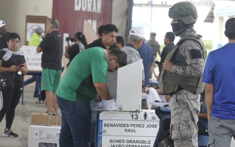 Ciudadanos votaron en la Unidad Educativa Fiscal Durán mientras la policía y los militares garantizan la seguridad.