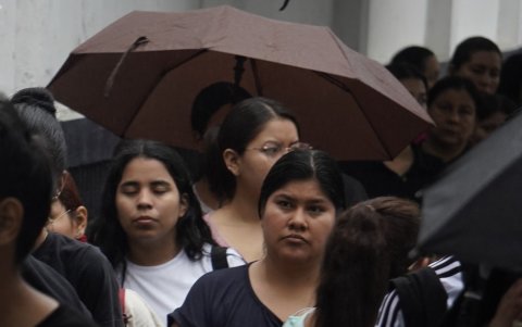 En varios puntos de la ciudad, la lluvia obligó a los votantes a protegerse.