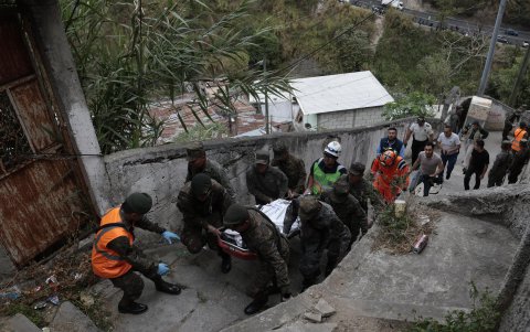 Integrantes de la unidad de rescate del ejercito trasladan uno de los fallecidos del accidente de un autobús a una morgue temporal este lunes, en el asentamiento Jesús de la Buena Esperanza.