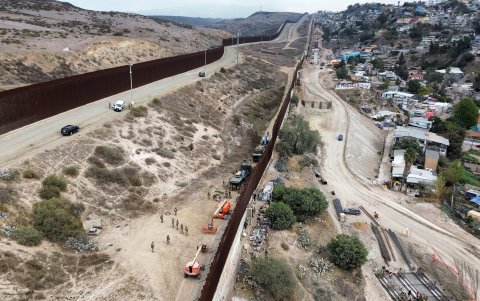 Fotografía aérea donde se observa a integrantes del ejercito de Estados Unidos reforzando un muro con alambre de púas este jueves, en la frontera con la ciudad de Tijuana, en Baja California (México).