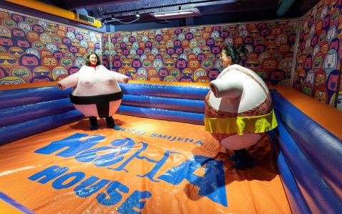 Los visitantes, vestidos con disfraces de peluche, luchan en la 'arena de sumo' del museo de la risa HaHaHouse en el centro de Zagreb, el 21 de enero de 2025