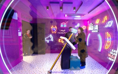 Zorica Bucic, una visitante de Split, canta en la sala de karaoke mientras visita el museo de la risa HaHaHouse en el centro de Zagreb, el 21 de enero de 2025.