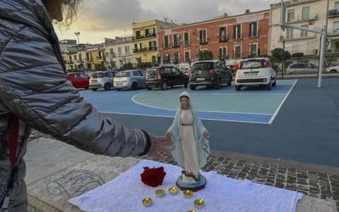 Un fiel reza el rosario frente a una estatua de la Virgen en la cancha de baloncesto del paseo marítimo de Pertini en Pozzuoli, cerca de Nápoles, Italia, el 17 de febrero de 2025.
