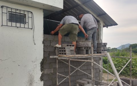 Obreros municipales reparando la pared.