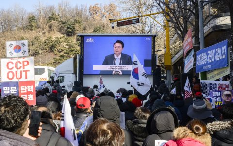Los partidarios miran imágenes de archivo de los discursos del líder surcoreano Yoon Suk Yeol (C) en una pantalla cerca del Tribunal del Distrito Central en Seúl el 20 de febrero de 2025.