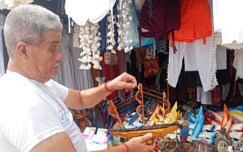 Un h9ombre observa varios trabajos hechos a manos por los artesanos de Playas.