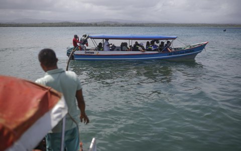 Migrantes venezolanos y colombianos salen una embarcación de la isla Gardi Sugdub con destino a Colombia este domingo, en la comarca Guna Yala, en Puerto de Cartí (Panamá).