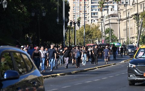 La gente camina en medio de la Avenida Alameda durante un apagón en Santiago el 25 de febrero de 2025.