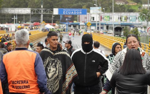 Varios de los indígenas que bloquean el paso en el puente internacional Rumichaca, aparecen frente a militares.