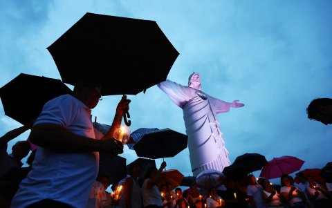 Fieles católicos sostienen velas durante una misa por la salud del Papa Francisco en el complejo de la estatua de Cristo Protector en Encantado, estado de Rio Grande do Sul.