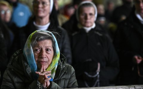 Una devota católica reza el rosario por la salud de Francisco.