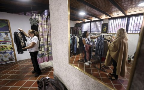 Maestros miran ropa dentro de una tienda de segunda mano administrada por la Federación Venezolana de Maestros (FVM) en Caracas, el 17 de febrero de 2025.