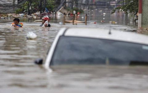 Dos personas cargan con agua en las calles anegadas de Bekasi, al oeste de la isla de Java, Indonesia este martes.