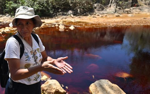 La ambientalista Vidalina Morales toma una muestra de agua del río San Sebastián contaminada por la actividad minera en Santa Rosa de Lima, departamento de La Unión, El Salvador.