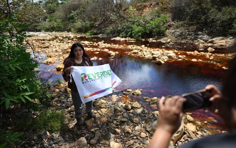 Un líder comunitario posa con una bandera en el río San Sebastián contaminado por la actividad minera en Santa Rosa de Lima, departamento de La Unión, El Salvador