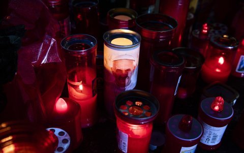 Velas encendidas frente a la estatua de Juan Pablo II a la entrada del hospital Gemelli, donde está hospitalizado el papa Francisco.