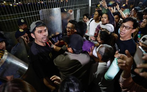 La policía impide que partidarios de Rodrigo Duterte lleguen a las vallas exteriores del campamento de la Fuerza Aérea, donde Duterte fue arrestado.