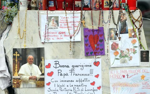 Velas, rosarios y mensajes de apoyo al papa Francisco se exhiben en la estatua del papa Juan Pablo II junto al Hospital Universitario Gemelli, donde está hospitalizado, en Roma.