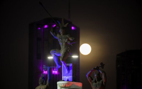 Vista de la luna llena delante de una estatua del Indio Guaicaipuro, este viernes, durante el eclipse lunar total conocido como 