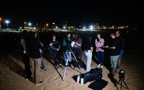 Varias personas observan un eclipse lunar total en la madrugada de este viernes, en Asunción (Paraguay).