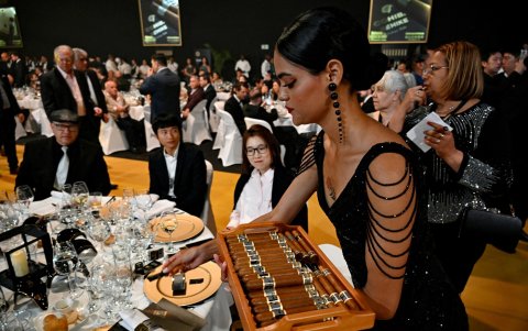 Una modelo distribuye puros durante una subasta realizada como parte de la clausura del XXV Festival del Habano en La Habana el 28 de febrero de 2025.