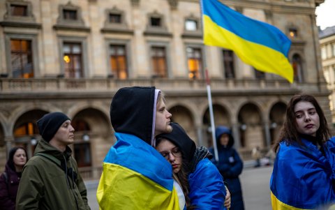 La gente asiste a una manifestación conmemorativa en el tercer aniversario del bombardeo del Teatro Dramático de Mariupol.