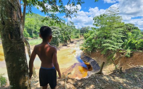 Un niño mira hacia el río, donde usualmente jugaba.