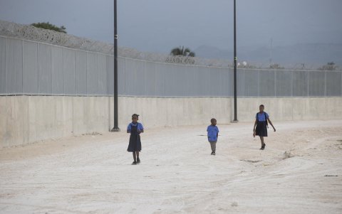 Fotografía del 20 de marzo de 2025 de estudiantes haitianos caminando junto al muro fronterizo, en Pedernales (República Dominicana).