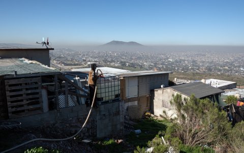 Santiago Castro, un repartidor de agua, llena un tanque de una casa en la Colonia Manantial en Tijuana, Estado de Baja California, México, el 24 de marzo de 2025.