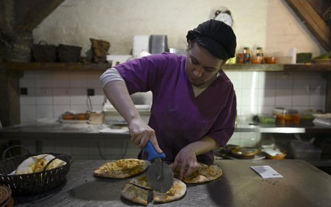 Un empleado corta pan plano en el restaurante Ethno House de Gracanica, un enclave serbio étnico a las afueras de Pristina.