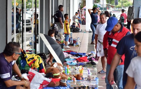 Productos. Peluches, camisetas, textos infantiles y otros artículos se exhiben sobre sábanas en la acera junto a una entidad bancaria de La Alborada.