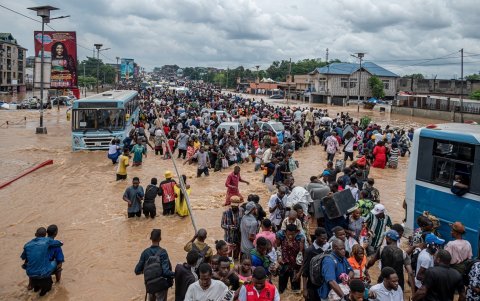 Los damnificados por las fuertes lluvias en la RDC caminan por calles inundadas hacia zonas más secas.