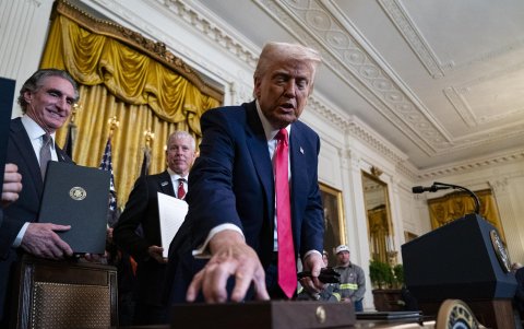 El presidente estadounidense, Donald Trump, reparte bolígrafos tras firmar órdenes ejecutivas durante una ceremonia en la Sala Este de la Casa Blanca en Washington, D.CL