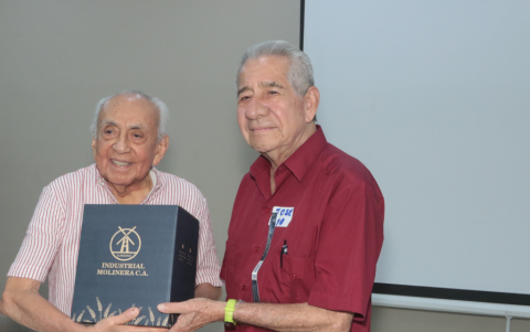 José Barrezueta recibe un reconocimiento de manos de Carlos Espinoza Proaño.