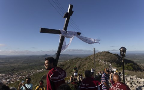 Un hombre sostiene una cruz durante la tradicional procesión al santuario del Monte Santo