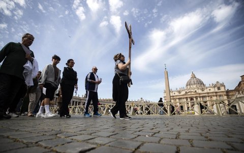 Un grupo de creyentes recorre la Plaza de San Pedro con una cruz lamentando la muerte del papa Francisco este lunes en el Vaticano.