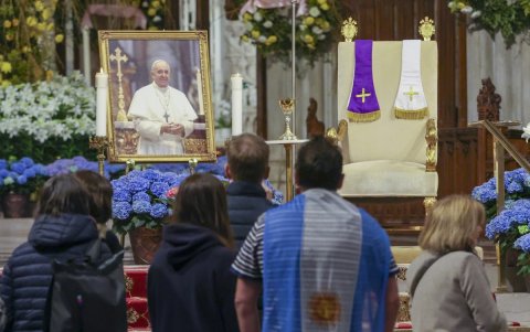 Una persona que lleva la bandera de Argentina mira una imagen del fallecido Papa Francisco dentro de la Catedral de San Patricio.