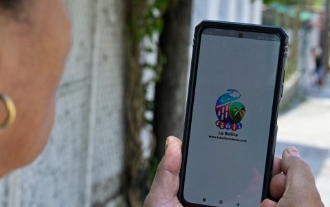 Una mujer revisa en una aplicación móvil los números ganadores del La loteria clandestina.