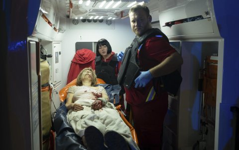 Personal médico ucraniano ayuda a una víctima en el lugar donde la noche del 23 de abril de 2025, un cohete impactó en un edificio residencial en Kievla.