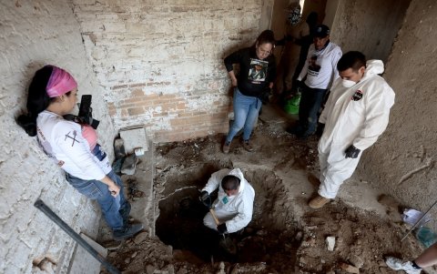Indira Navarro (izq.) y miembros del colectivo “Guerreros Buscadores” trabajan en una casa abandonada utilizada para vender drogas luego de encontrar restos humanos en Guadalajara, Jalisco.