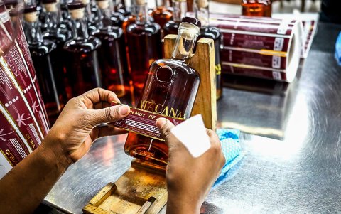 Etiquetado. Momento en que se pone la etiqueta a una botella del ron Puntacana, que ahora se envasa en Ecuador.