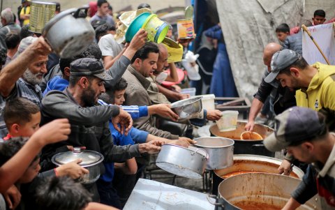 Muchos palestinos tienen que buscar entre los escombros algo para comer. Aquí reciben un poco de alimento.