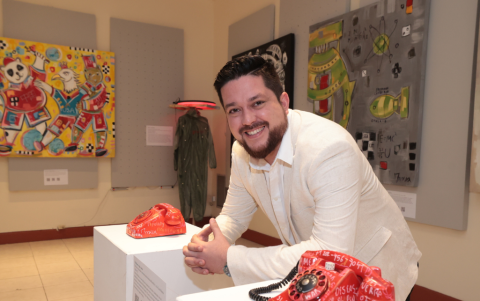 El artista posa orgulloso junto a parte de su obra.