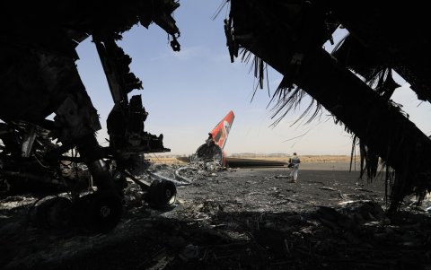 Un rebelde hutí camina junto a un avión destruido en el Aeropuerto Internacional de Saná el 7 de mayo de 2025.