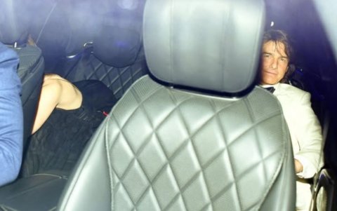 Cruise siendo captado junto a De Armas que se oculta de las cámaras a la salida de la fiesta de David Beckham