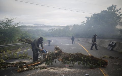 Integrantes de la Unidad de Control de Multitudes de Panamá (UCM) y manifestantes se enfrentan durante una protesta este miércoles, en Viguí Veraguas (Panamá).