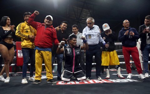 Tzamarenda de rodillas con el grupo que lo acompaña en su regreso.