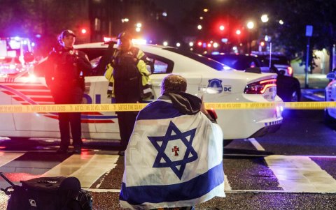 Un hombre con una bandera israelí este jueves en el lugar donde fueron asesinadas dos personas que trabajaban en la embajada de Israel en Washington.