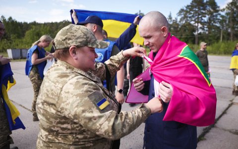 Prisioneros de guerra ucranianos sosteniendo banderas después de su intercambio, en medio de la invasión rusa en Ucrania.